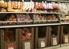 Diverse tipologie di cipolle, aglio e scalogno. Sotto, in grosse casse, le patate.