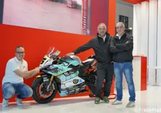 Vanni Vignali ci mostra il dettaglio del marchio Vignali su questa motocicletta da corsa. Accanto a lui, Fabio Vignali e Samuele Zanelli.