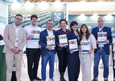 Lo staff DECCO Italia in fiera, mentre mostra alcune brochure illustrative sui suoi prodotti per l'agricoltura.
