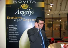 Simone Spreafico impegnato in una conversazione telefonica. Alle sue spalle, il nuovo marchio Angélys, per la pera ad alta conservabilità (vedi anche articolo correlato).