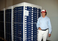 Stefano Pezzo posa accanto ai pallet di ciliegie già confezionate per conto della Greenery.