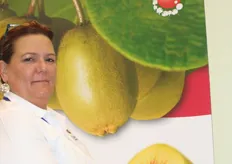 Dawn Gray mostra la nuova varietà di mela Envy, con sullo sfondo tutte le varietà di kiwi Sunrising della ENZA.