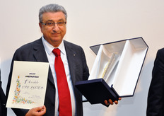 Gianni Bonora mostra il premio ricevuto.