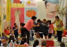 Lo stand Alimos si caratterizza ogni anno per diverse iniziative rivolte ai piu' piccoli. In questo caso, i bambini stanno sperimentando la pigiatura dell'uva a piedi nudi.