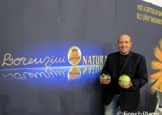 Cristiano Lorenzini tiene in mano un melone e una confezione di pomodori datterini.