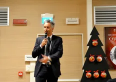 Maurizio Pisani accanto all'albero di Natale decorato con i pomodorini.