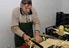 Taglio della base di un mazzo di asparagi verdi.