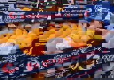 Confezioni di pesche gialle spagnole in mostra nel mercato.