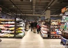 Il supermercato del futuro e' stato realizzato in materiali caldi, mentre le corsie sono piu' distanziate che in un supermercato tradizionale. Il risultato e' un negozio piu' accogliente.