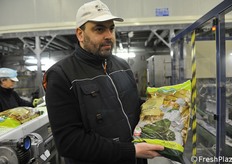 Gianluca del Corvo direttore di stabilimento mostra una busta di spinaci surgelati.