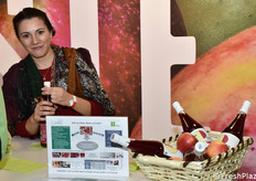 Un'addetta pronta a offrire un bicchierino di succo di mela e barbabietola rossa EvaBio proposto dal Centro Laimburg.